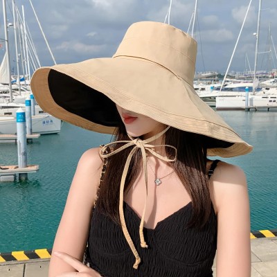 Woman wearing reversible wide brim sun hat with UV protection at beach
