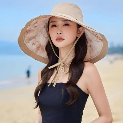 Woman wearing reversible wide brim sun hat with metal wired edge at beach