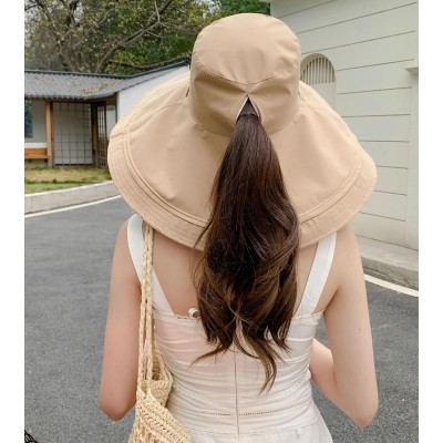 Woman wearing reversible wide brim sun hat with metal wired edge at beach
