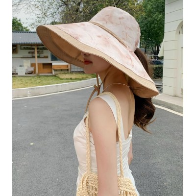 Woman wearing reversible wide brim sun hat with metal wired edge at beach