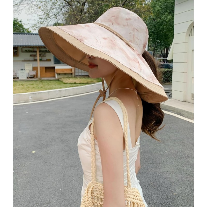 Woman wearing reversible wide brim sun hat with metal wired edge at beach