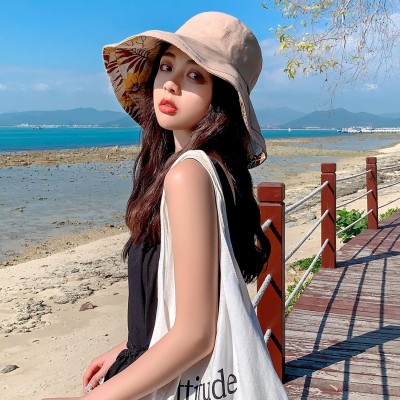 Woman wearing a wide brim reversible sun hat with UV protection