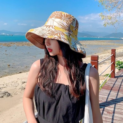Woman wearing a wide brim reversible sun hat with UV protection