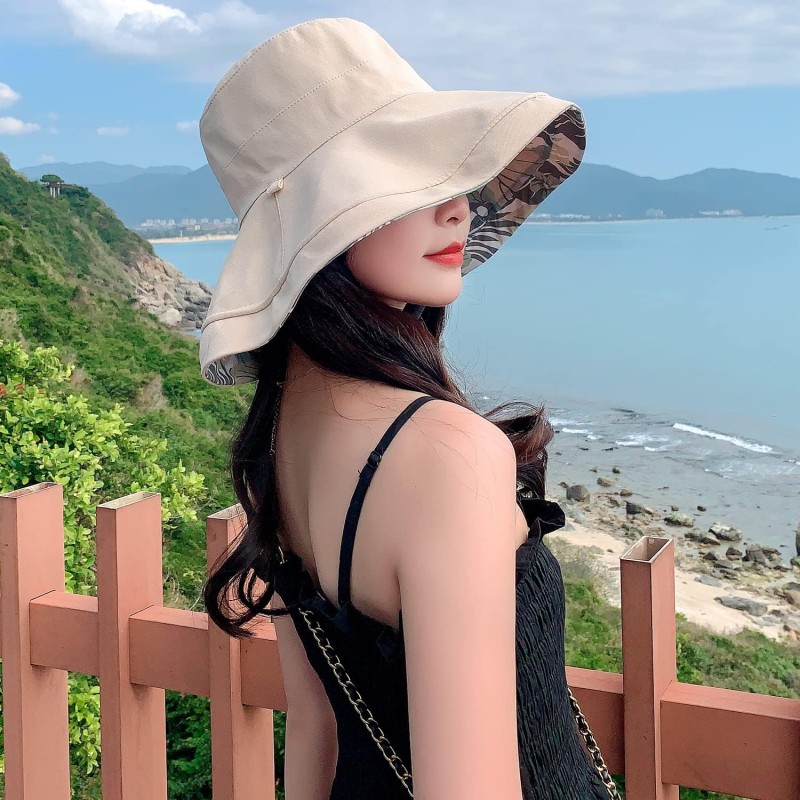 Woman wearing HUAMULAN reversible wide brim sun hat with UV protection