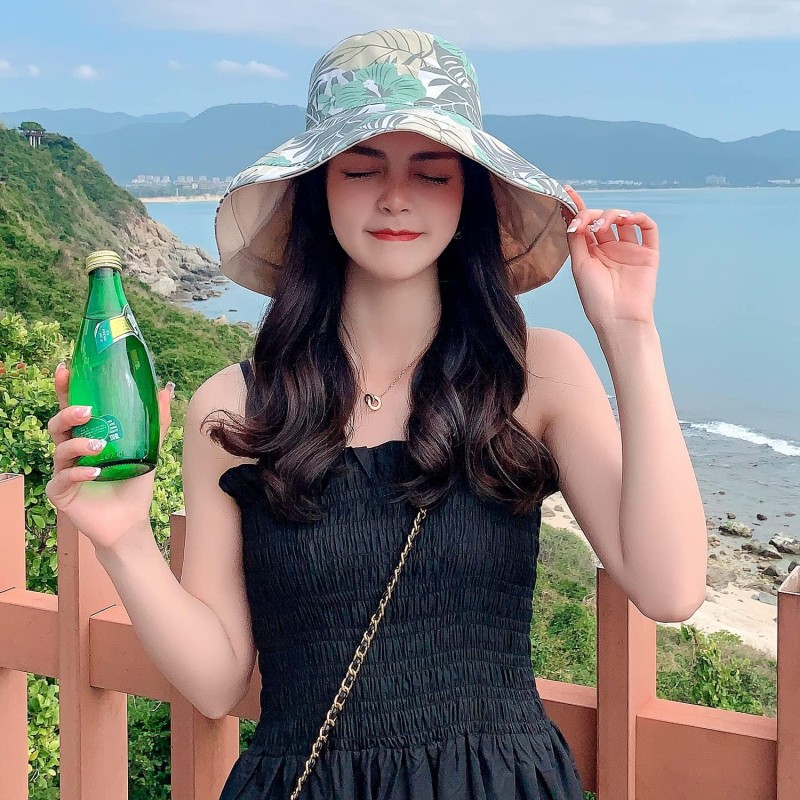 Woman wearing HUAMULAN reversible wide brim sun hat with UV protection