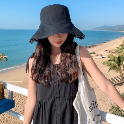 Women's Reversible Wide Brim Sun Hat – UV Protection & Foldable Beach Hat Women wearing a reversible wide brim sun hat with UV protection at the beach